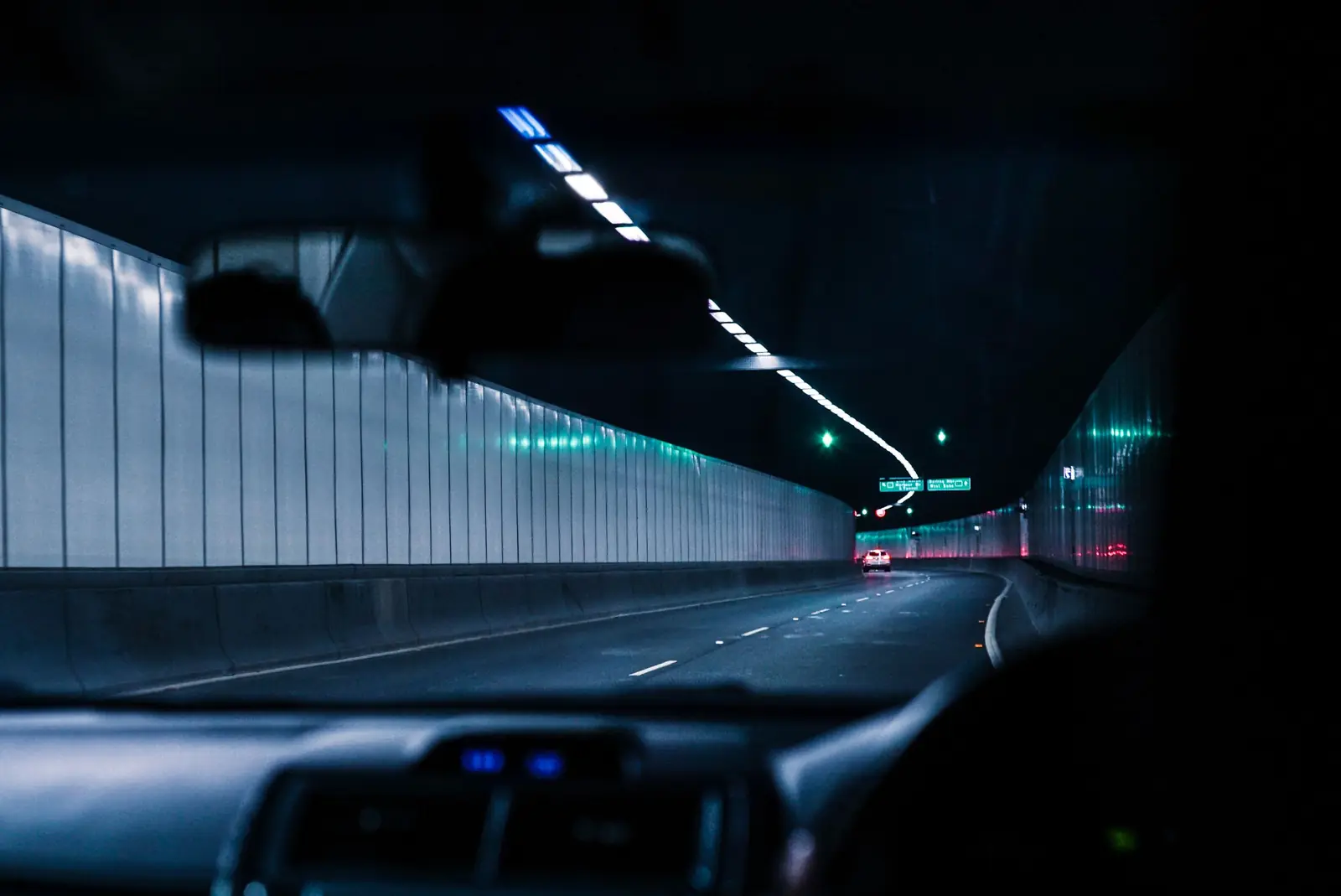 Fahrt durch einen beleuchteten Tunnel, Blick durch die Windschutzscheibe
